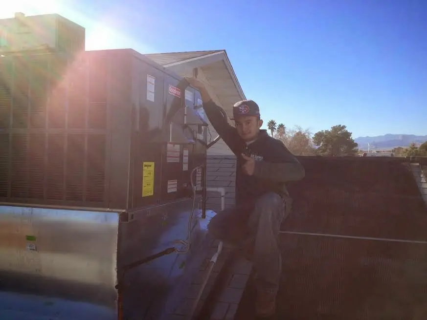 HVAC technician performing HVAC Inspection on a rooftop unit in Muscoy